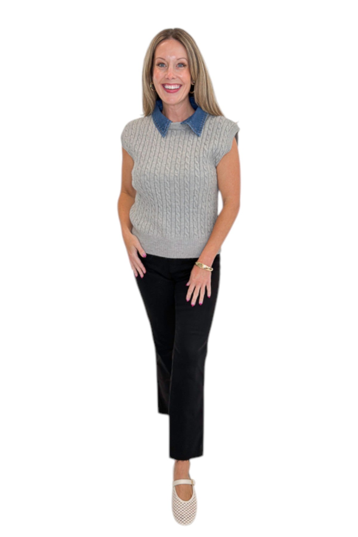 Front view of woman wearing Swagger Boutique’s Grey Cable Knit Denim Collared Sleeveless Sweater with jeans against white studio background.