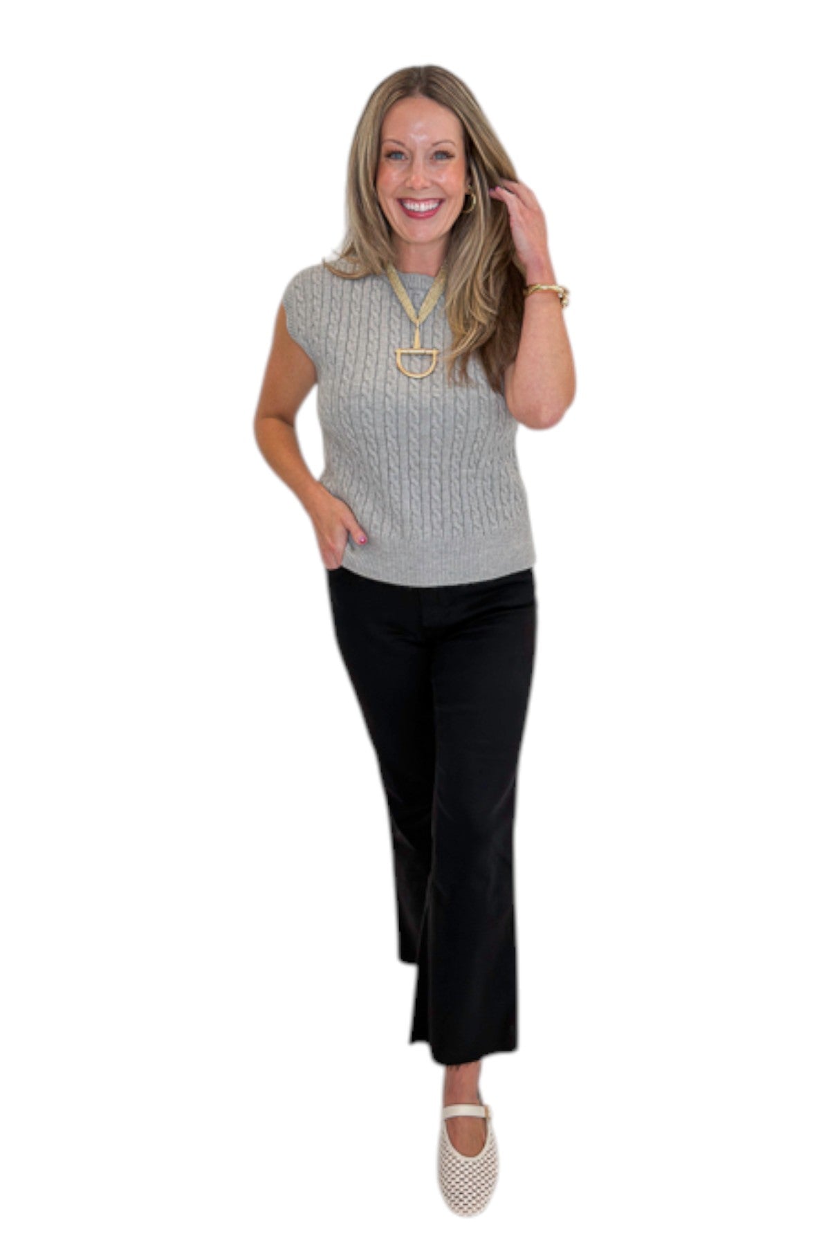 Front view of woman wearing Swagger Boutique’s Grey Cable Knit Denim Collared Sleeveless Sweater with jeans against white studio background.