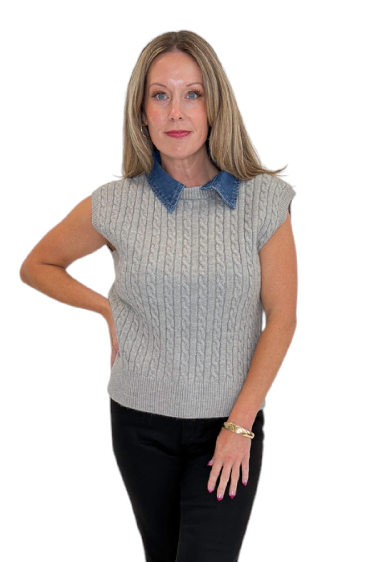 Front view of woman wearing Swagger Boutique’s Grey Cable Knit Denim Collared Sleeveless Sweater with jeans against white studio background.