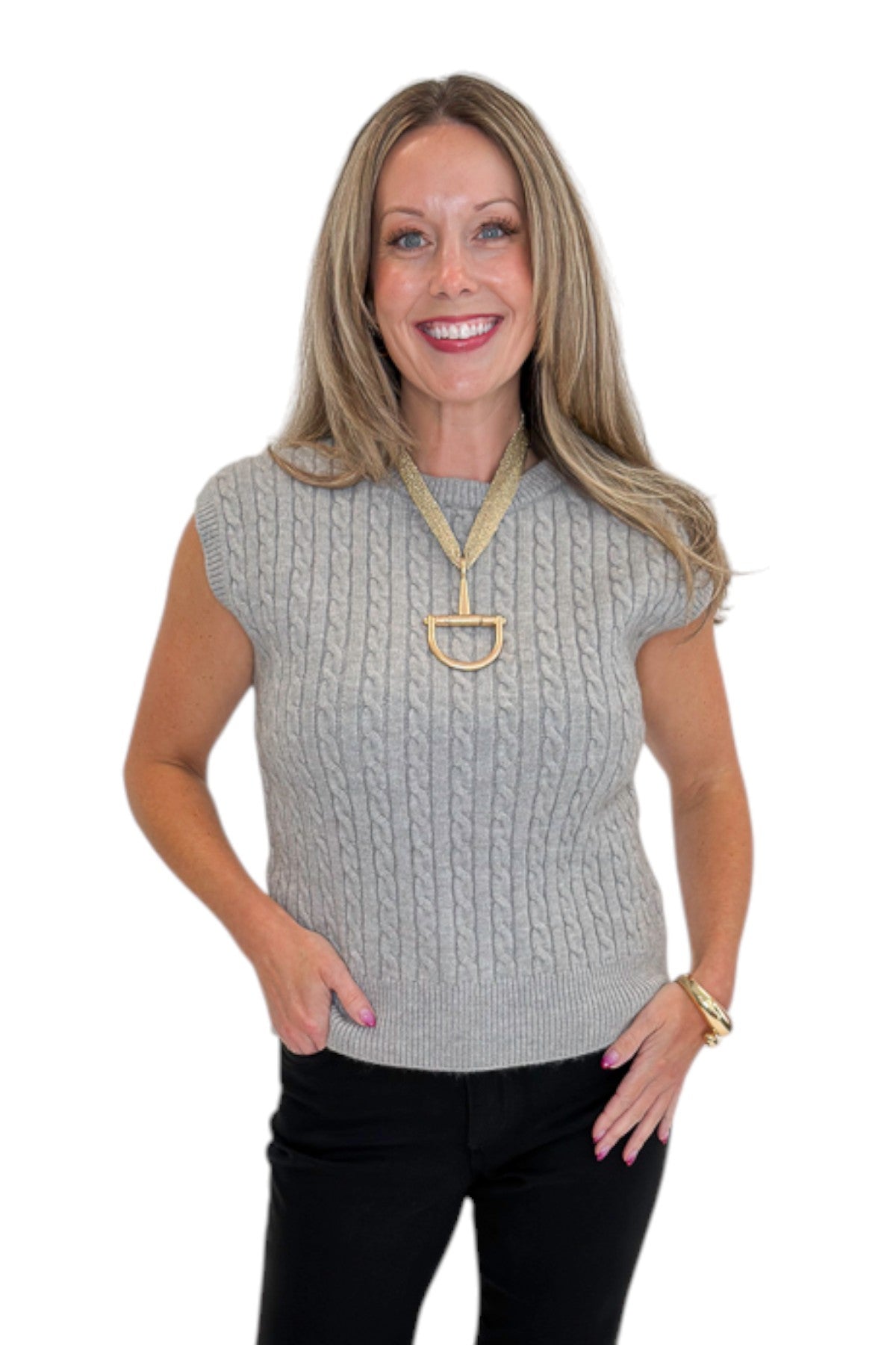 Front view of woman wearing Swagger Boutique’s Grey Cable Knit Denim Collared Sleeveless Sweater with jeans against white studio background.