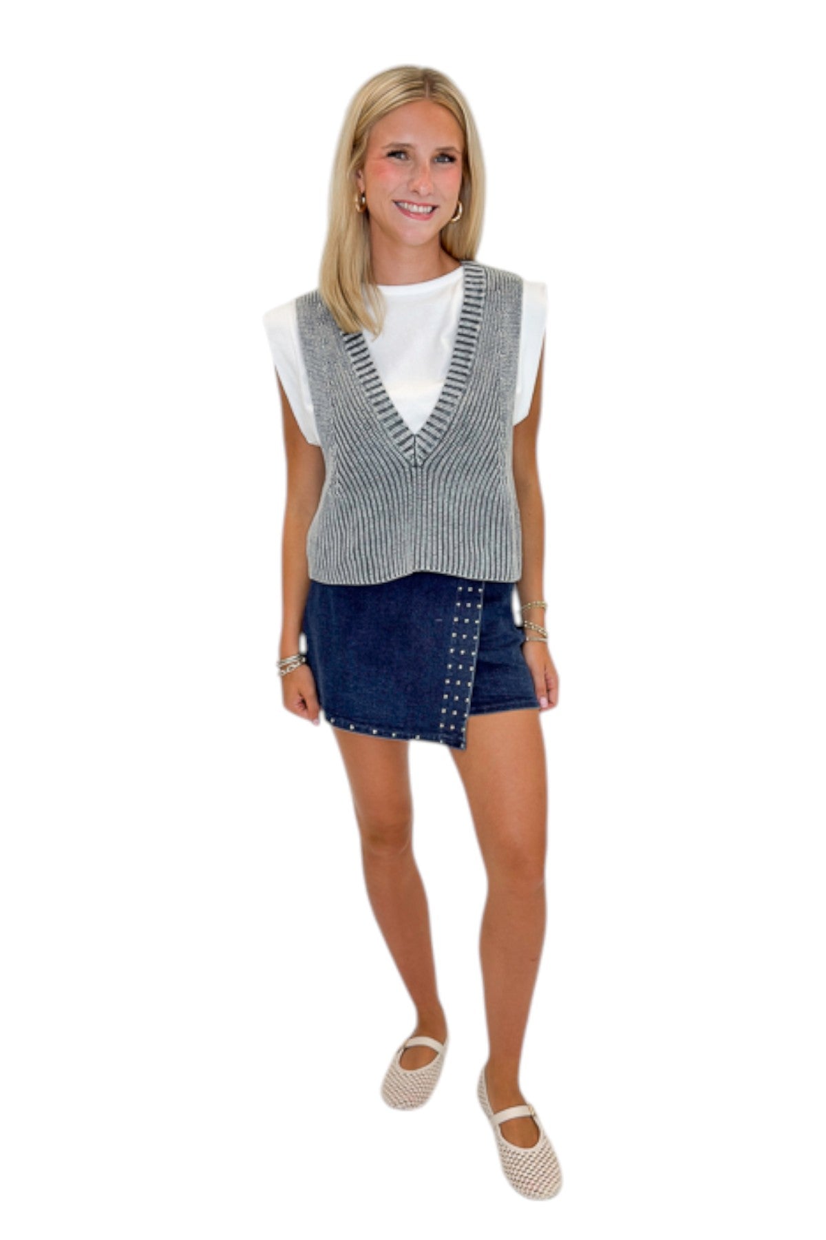 Front view of woman wearing Swagger Boutique’s Grey Layered Sweater Top with Dark Wash Studded Denim Skort against white studio background.