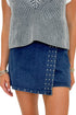 Front detail view of woman wearing Swagger Boutique’s Grey Layered Sweater Top with Dark Wash Studded Denim Skort against white studio background.