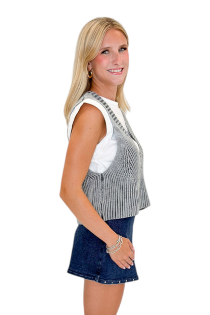 Side view of woman wearing Swagger Boutique’s Grey Layered Sweater Top with Dark Wash Studded Denim Skort against white studio background.