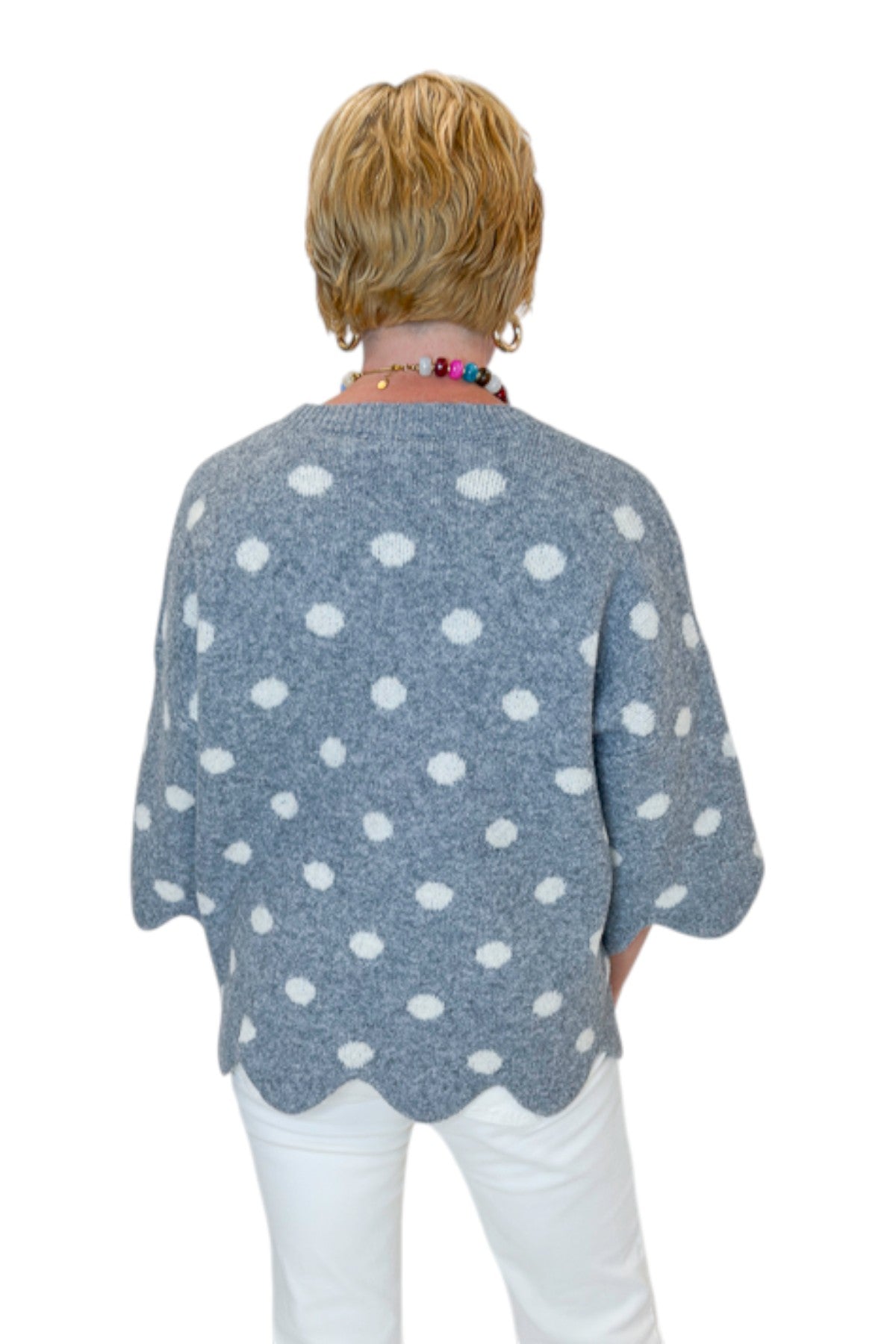Back view of woman wearing Swagger Boutique’s Grey Polka Dot Short Sleeve Sweater by Entro with jeans against white studio background.
