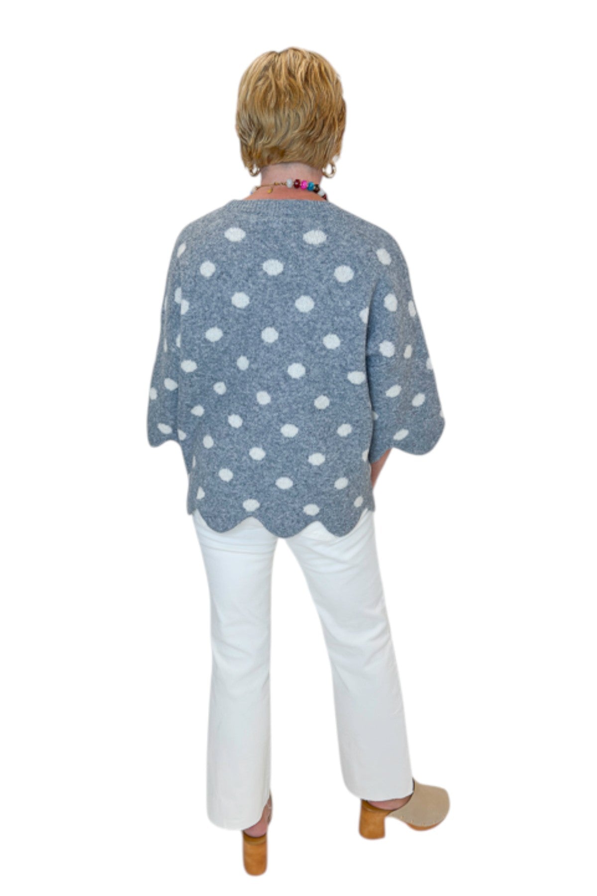 Back view of woman wearing Swagger Boutique’s Grey Polka Dot Short Sleeve Sweater by Entro with jeans against white studio background.