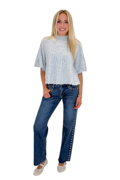 Front view of woman wearing Swagger Boutique’s Grey Ribbed Short Sleeve Sweater with jeans against white studio background.