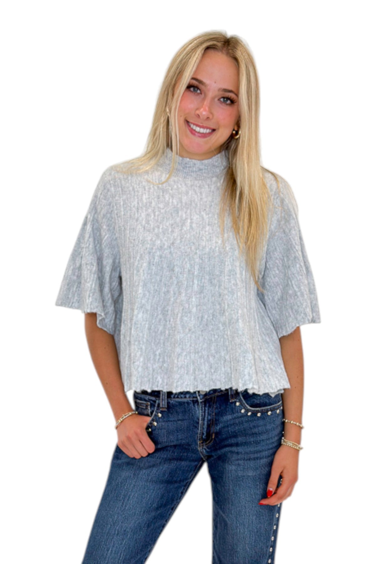 Front view of woman wearing Swagger Boutique’s Grey Ribbed Short Sleeve Sweater with jeans against white studio background.