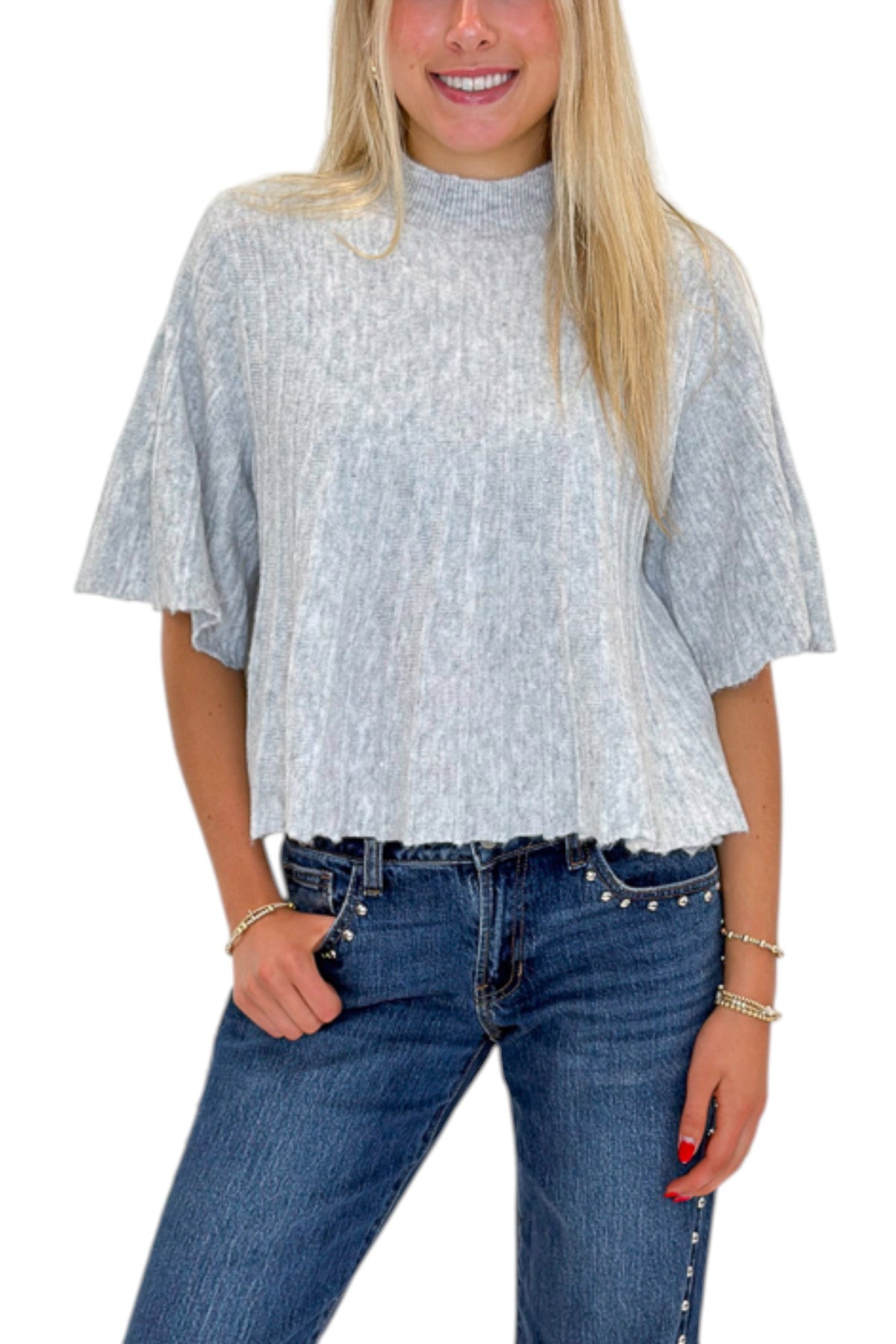 Front detail view of woman wearing Swagger Boutique’s Grey Ribbed Short Sleeve Sweater with jeans against white studio background.