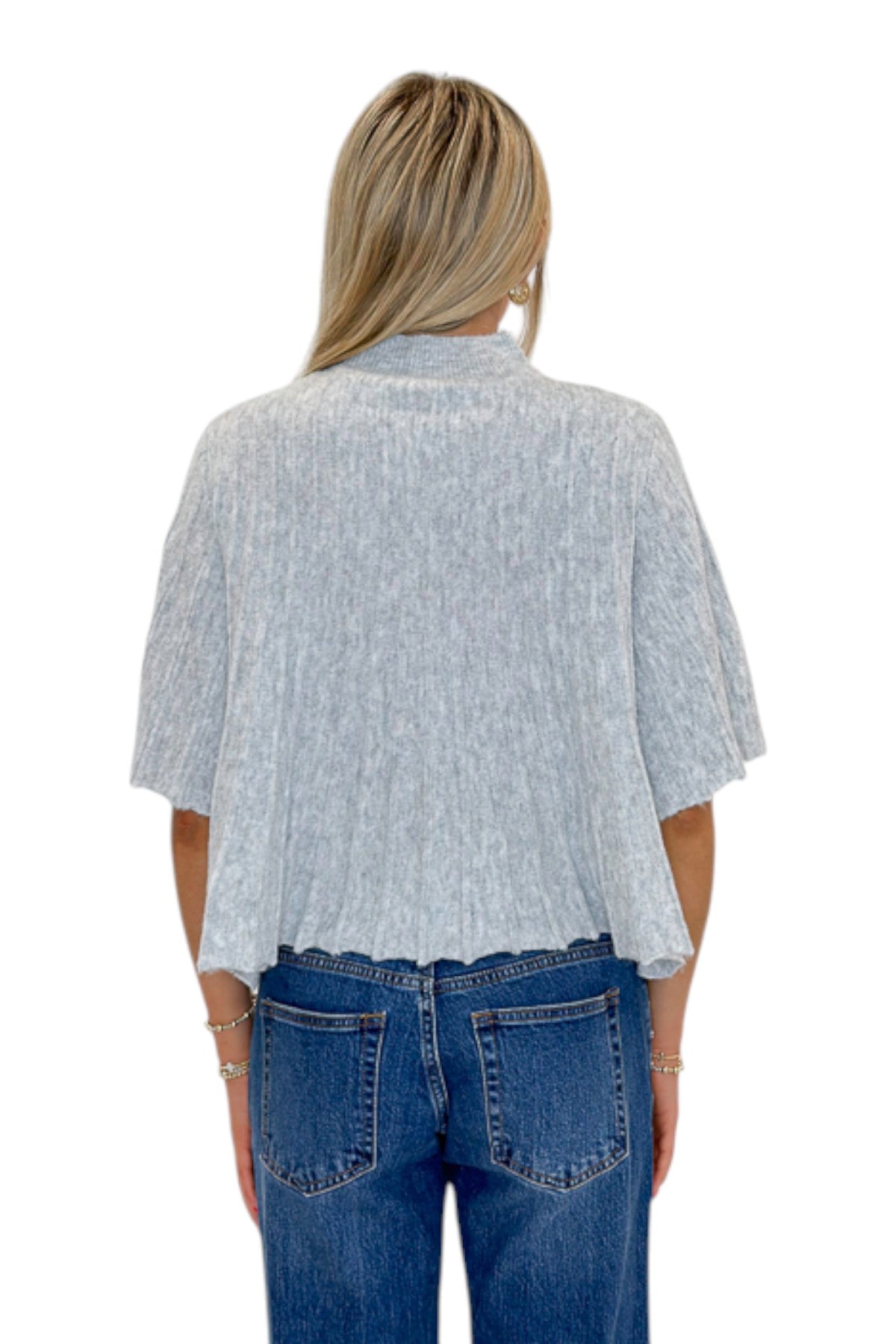 Back view of woman wearing Swagger Boutique’s Grey Ribbed Short Sleeve Sweater with jeans against white studio background.