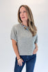 Front view of woman wearing Swagger Boutique’s Grey Short Sleeve Sweater with jeans against white studio background.