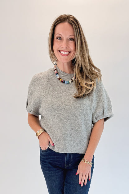 Front view of woman wearing Swagger Boutique’s Grey Short Sleeve Sweater with jeans against white studio background.