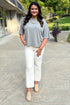 Front view of woman wearing Swagger Boutique’s Grey Short Sleeve Sweater with jeans walking outside.