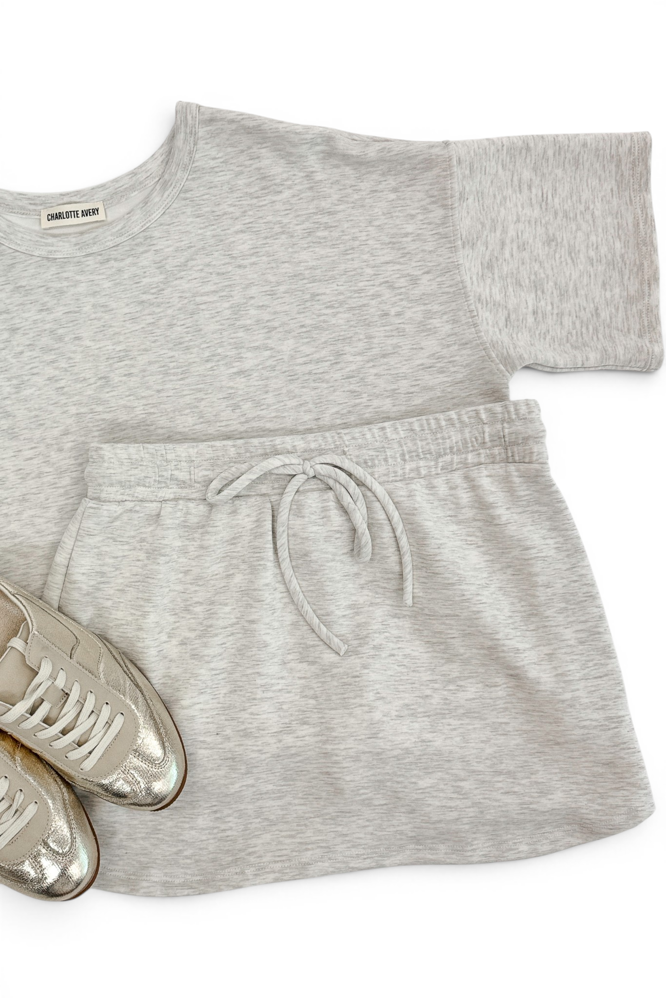 Grey Round Neck Short Sleeve Top with matching Grey Skort and sneakers against white studio background.