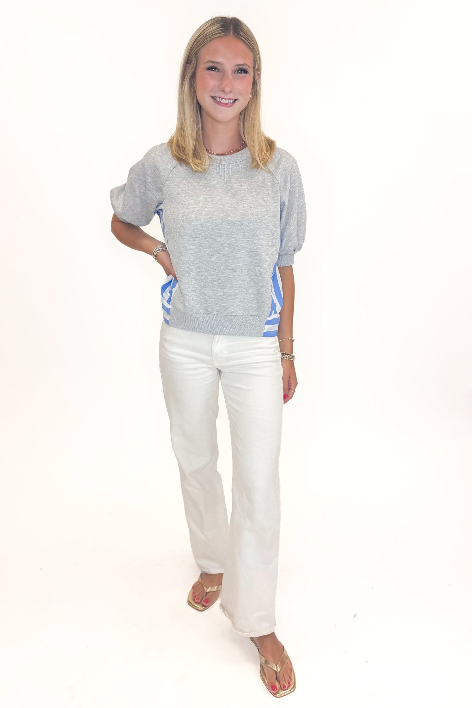 Front view of woman wearing Swagger Boutique’s Grey Striped Short Sleeve Sweatshirt with jeans against white studio background.