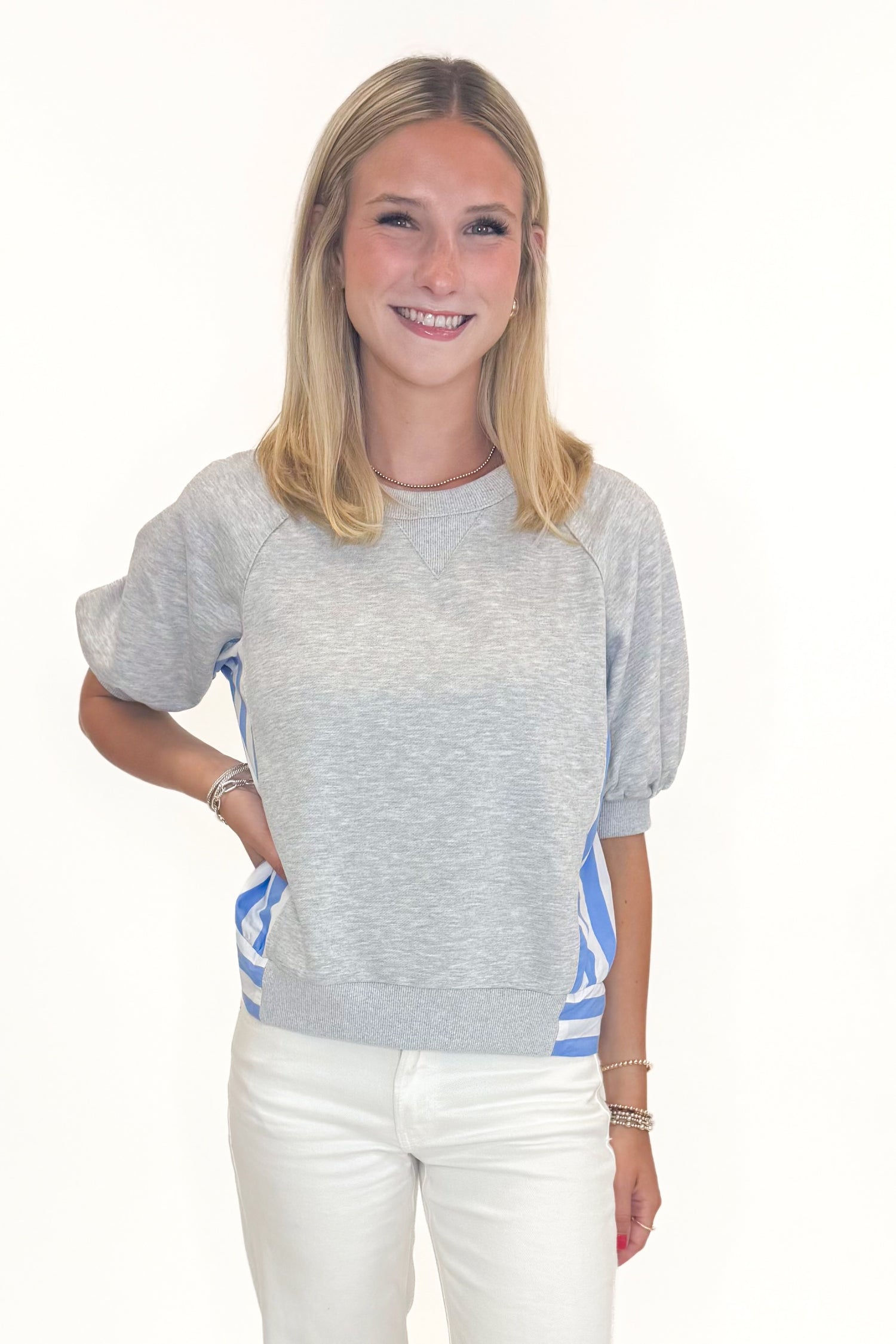 Front view of woman wearing Swagger Boutique’s Grey Striped Short Sleeve Sweatshirt with jeans against white studio background.