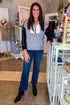 Front view of woman wearing Swagger Boutique’s Grey & Black Color Block 1/4 Zip Sweater with jeans standing at the store.