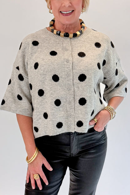 Front detail view of woman wearing Swagger Boutique’s Grey &amp; Black Polka Dot Short Sleeve Cardigan with jeans against white studio background.