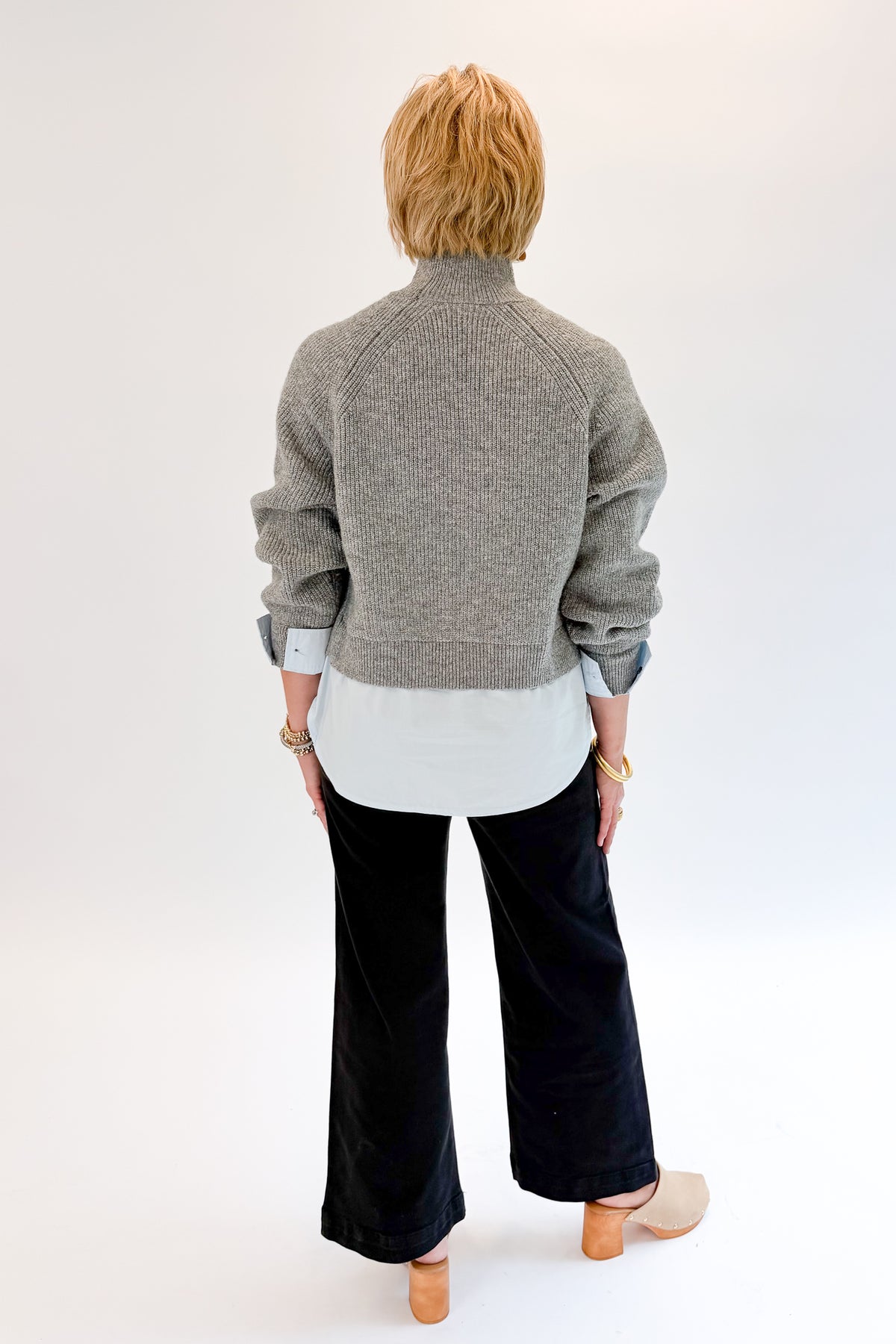 Back view of woman wearing Swagger Boutique’s Grey &amp; Blue Layered Sweater &amp; Shirt by Entro with jeans against white studio background.