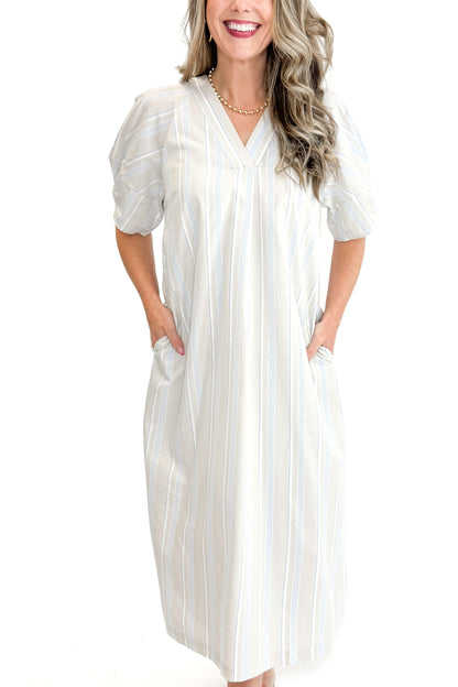 Front detail view of woman wearing Beige &amp; Light Blue Striped Midi Dress against white studio background.