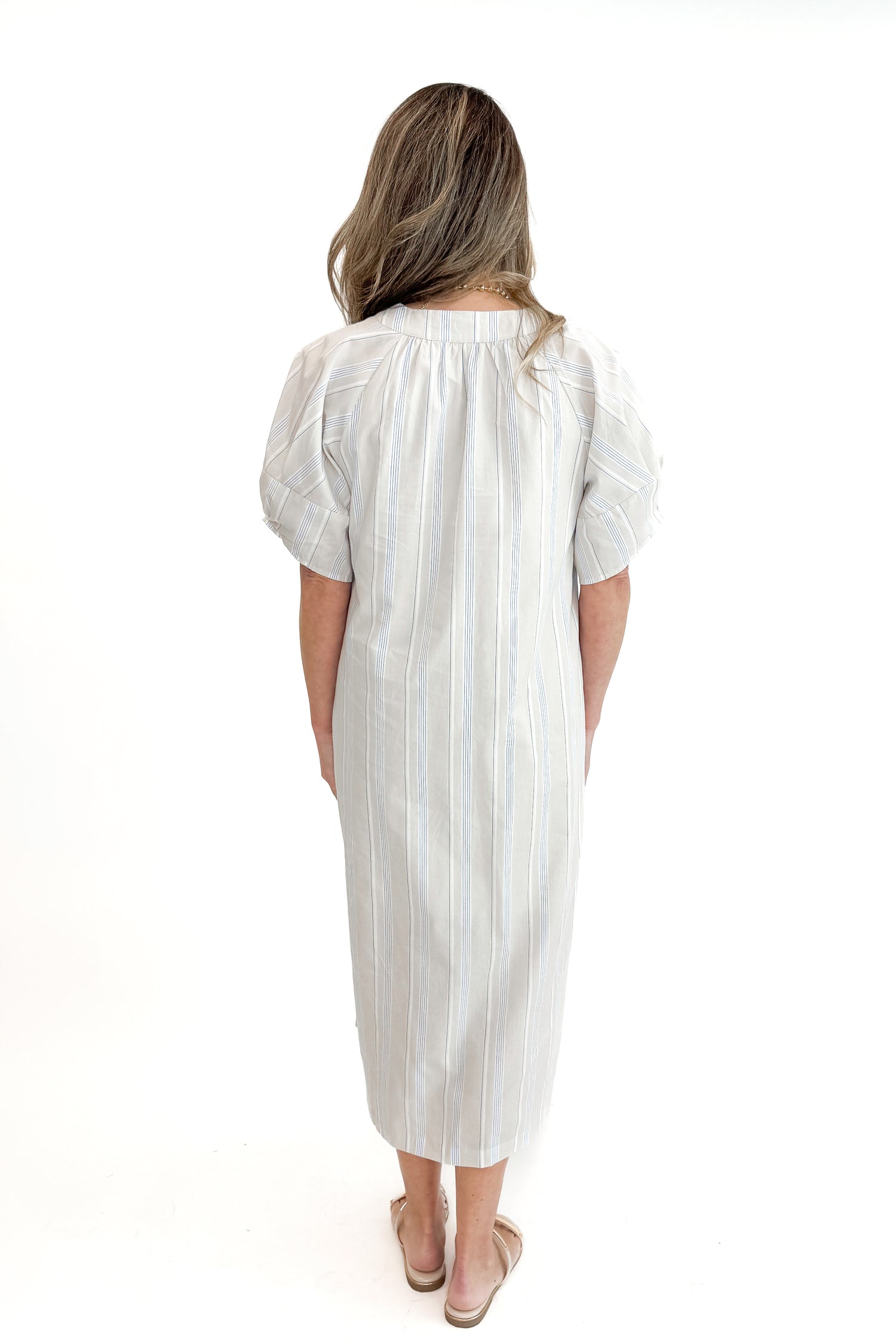 Back view of woman wearing Beige &amp; Light Blue Striped Midi Dress against white studio background.