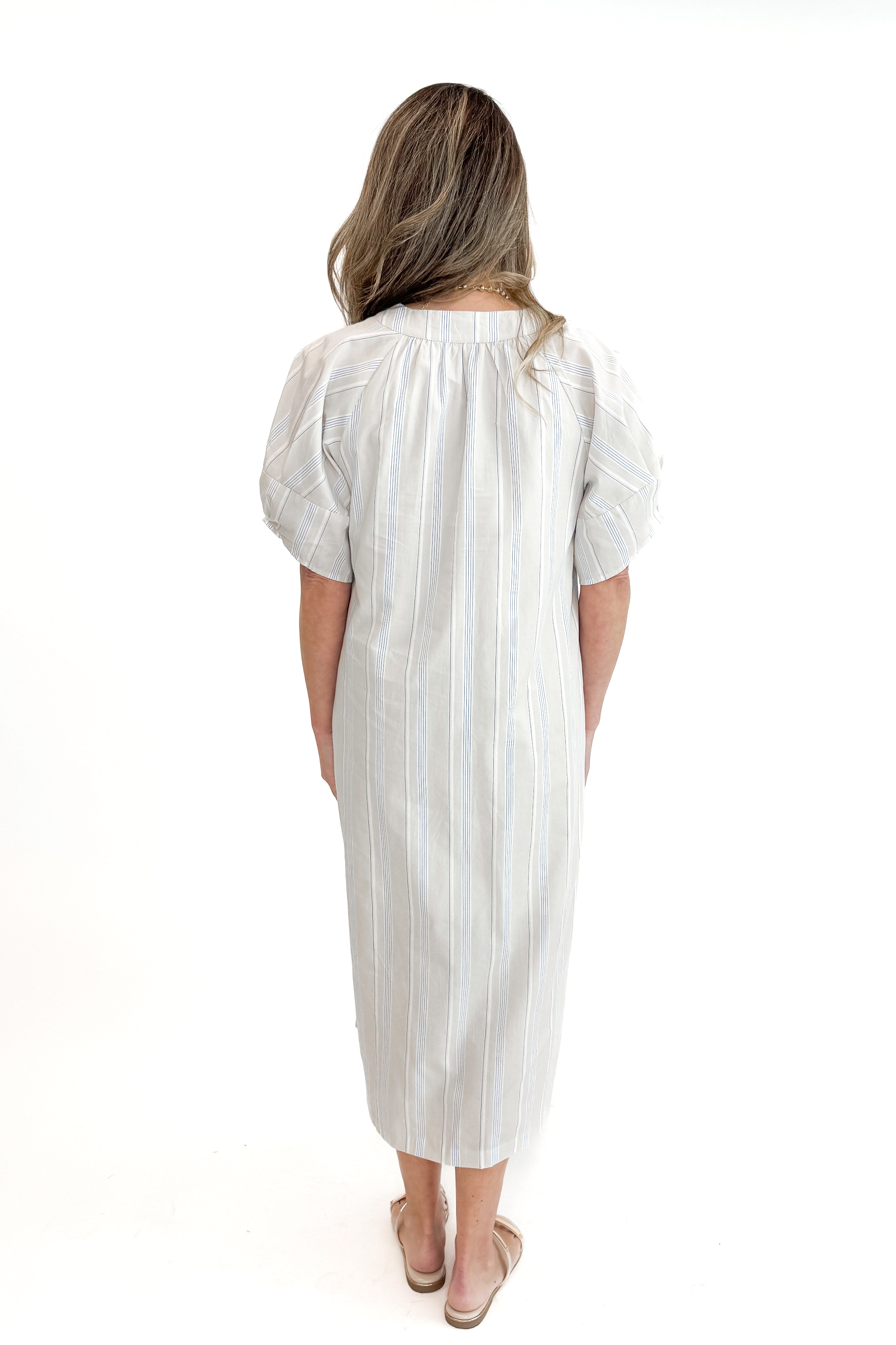 Back view of woman wearing Beige &amp; Light Blue Striped Midi Dress against white studio background.