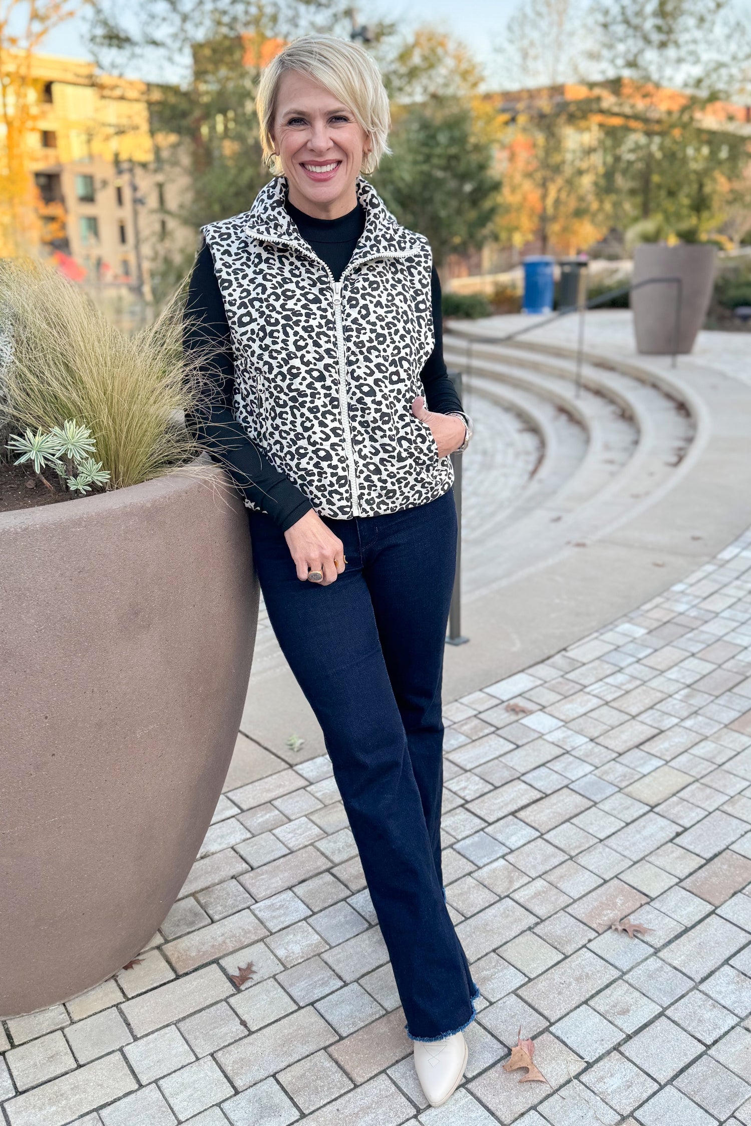 Front view of woman wearing Cream Leopard Puffer Vest with jeans outside.