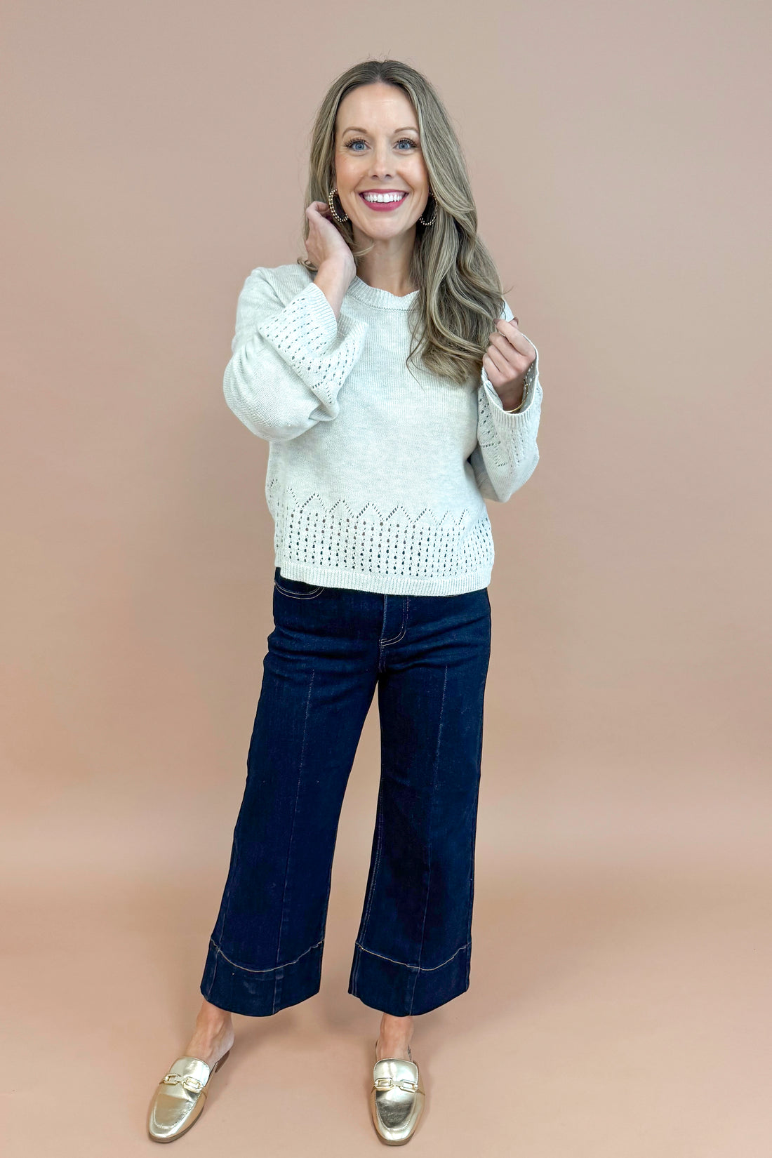 Woman wearing Grey Cutout Detail Sweater and blue jeans.