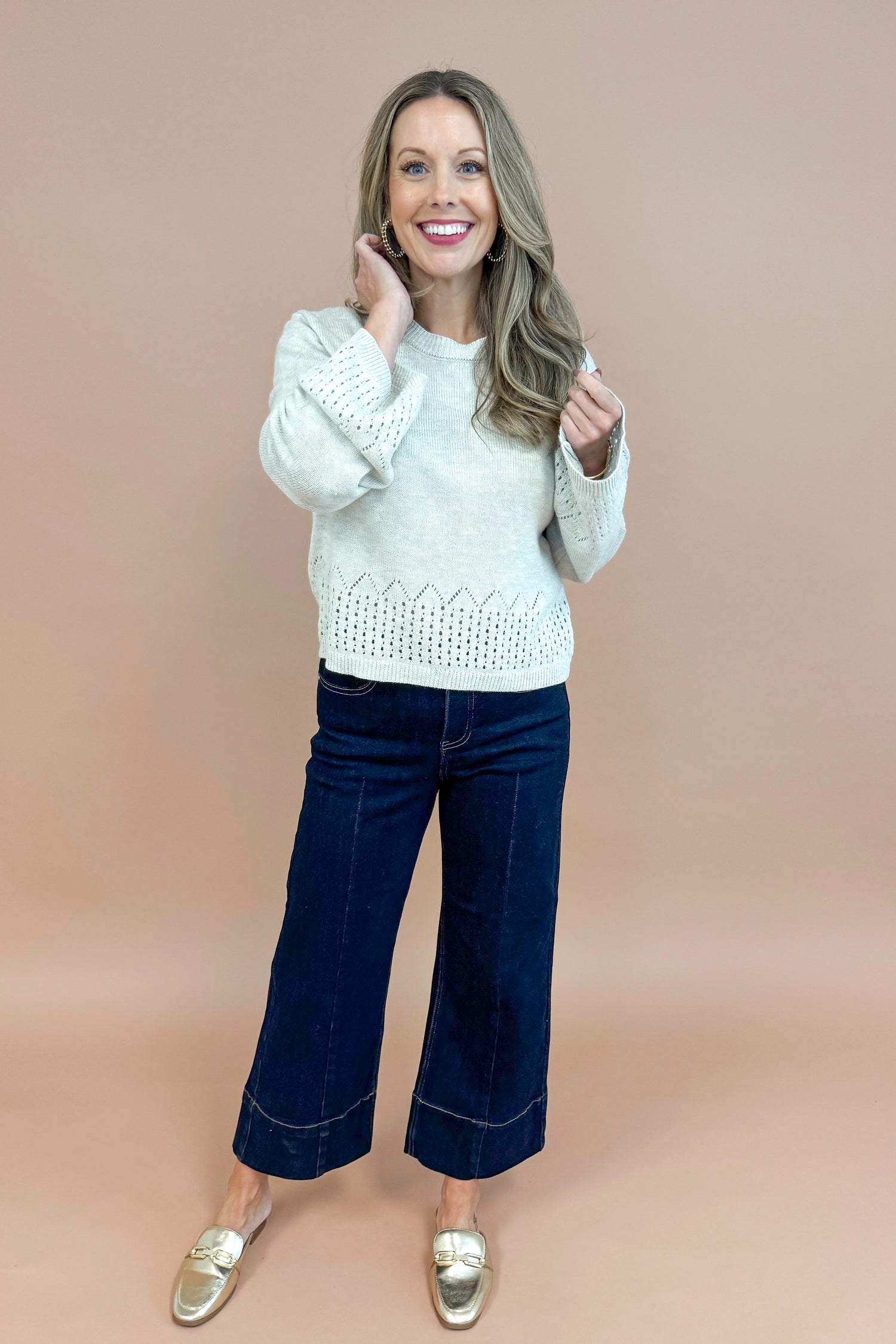 Woman wearing Grey Cutout Detail Sweater and blue jeans. 