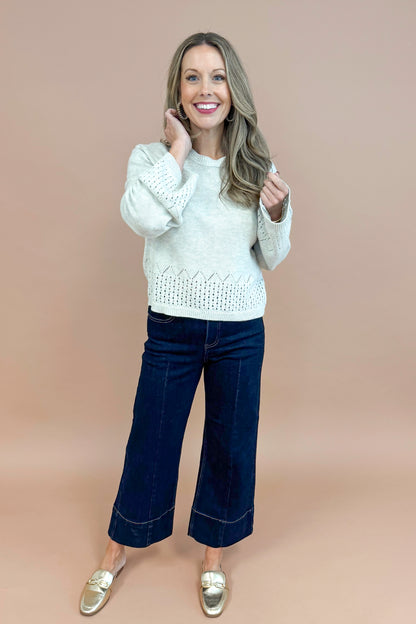 Woman wearing Grey Cutout Detail Sweater and blue jeans. 
