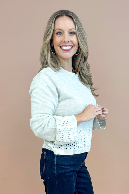 Side view of woman wearing Grey Cutout Detail Sweater and blue jeans. 