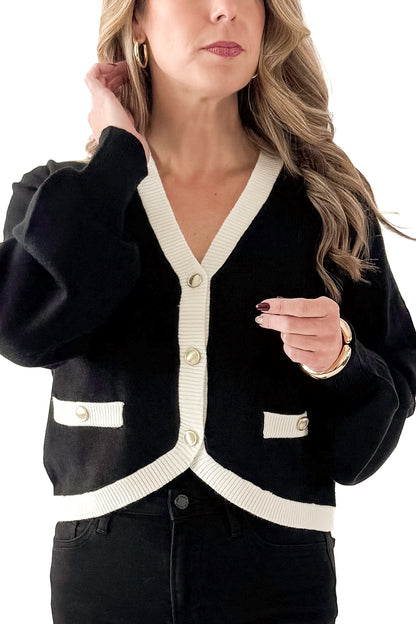 Front detailed view of woman wearing Black &amp; White Contrast Trim Cardigan with jeans against white studio background.