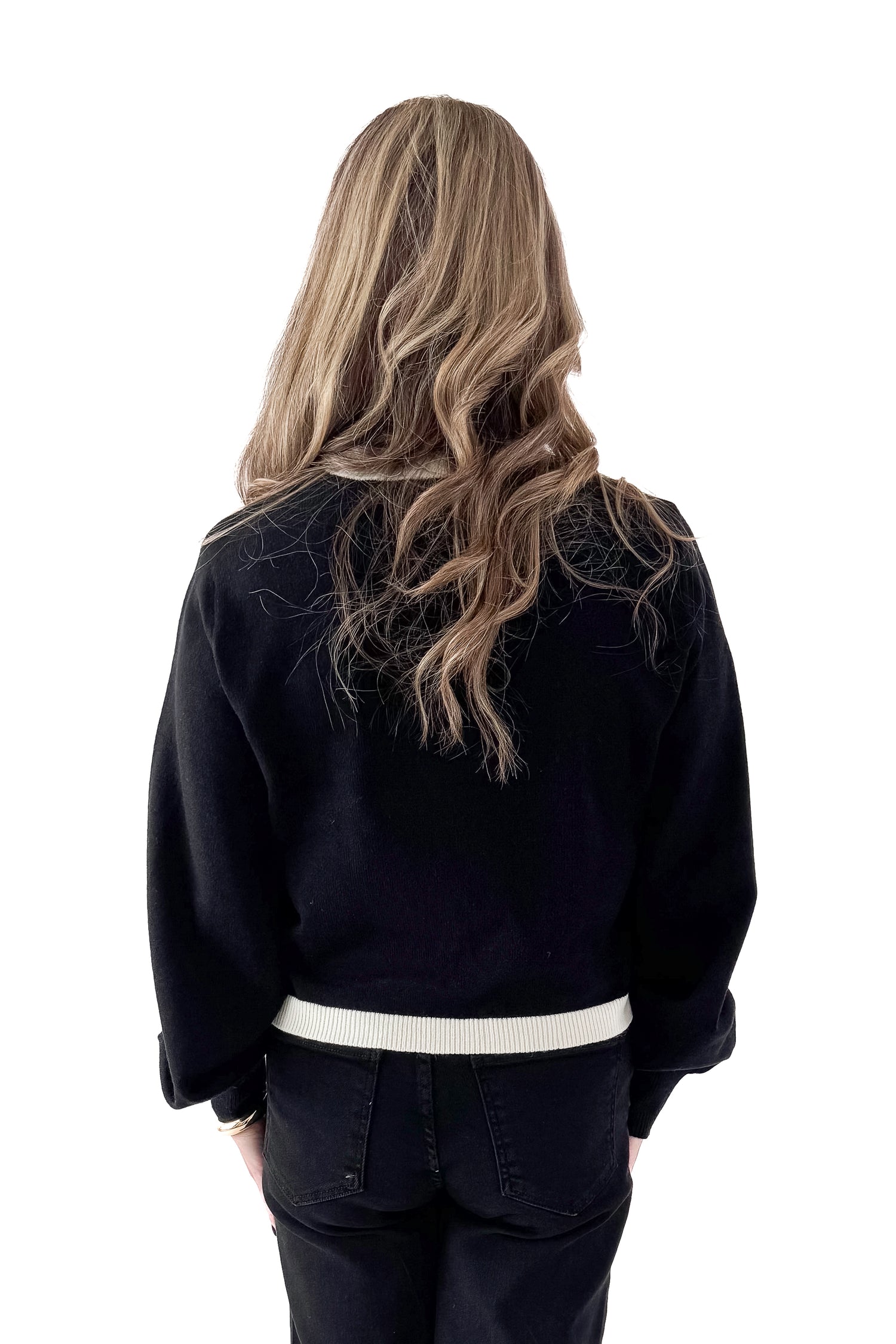 Back view of woman wearing Black &amp; White Contrast Trim Cardigan with jeans against white studio background.