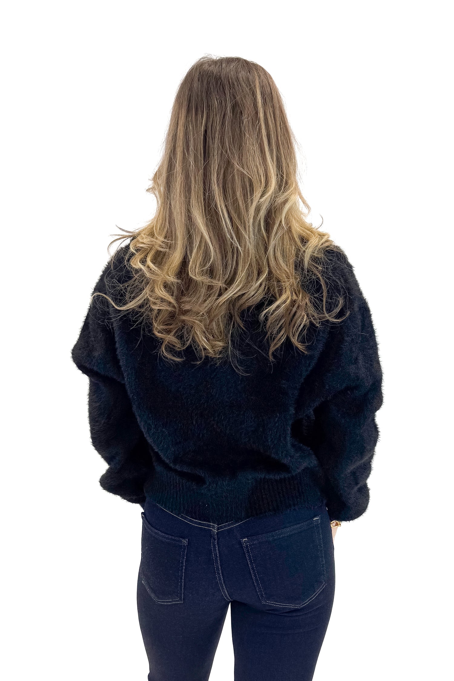 Back view of woman wearing Black Eyelash Tie Detail Cardigan with jeans against white studio background.