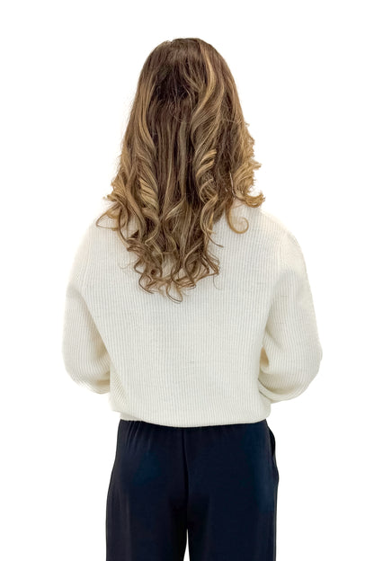Back view of woman wearing Cream Cardigan With Rhinestone Bow with pants against white studio background.