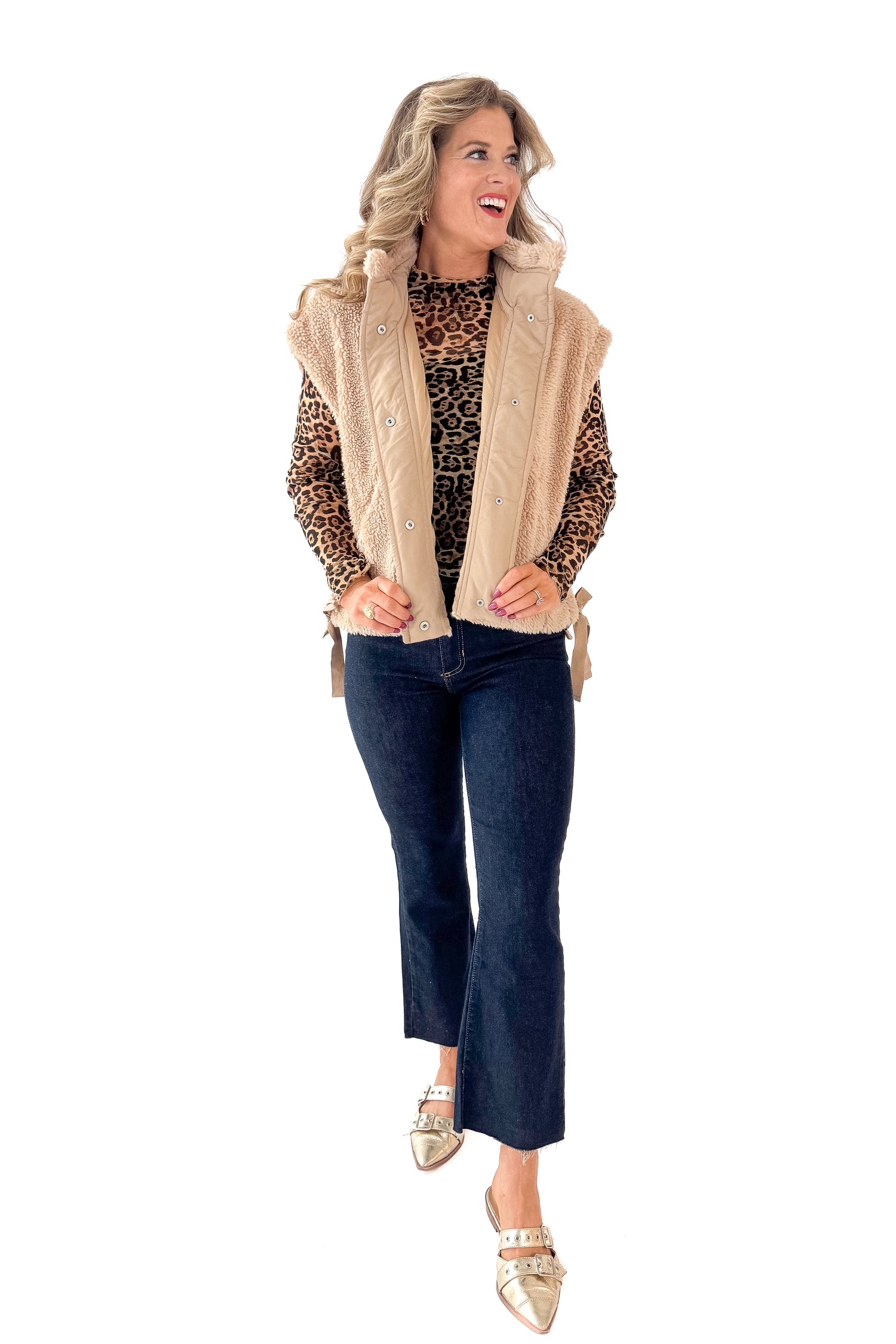 Front view of woman wearing Taupe Sherpa Button Up Vest with jeans against white studio background.