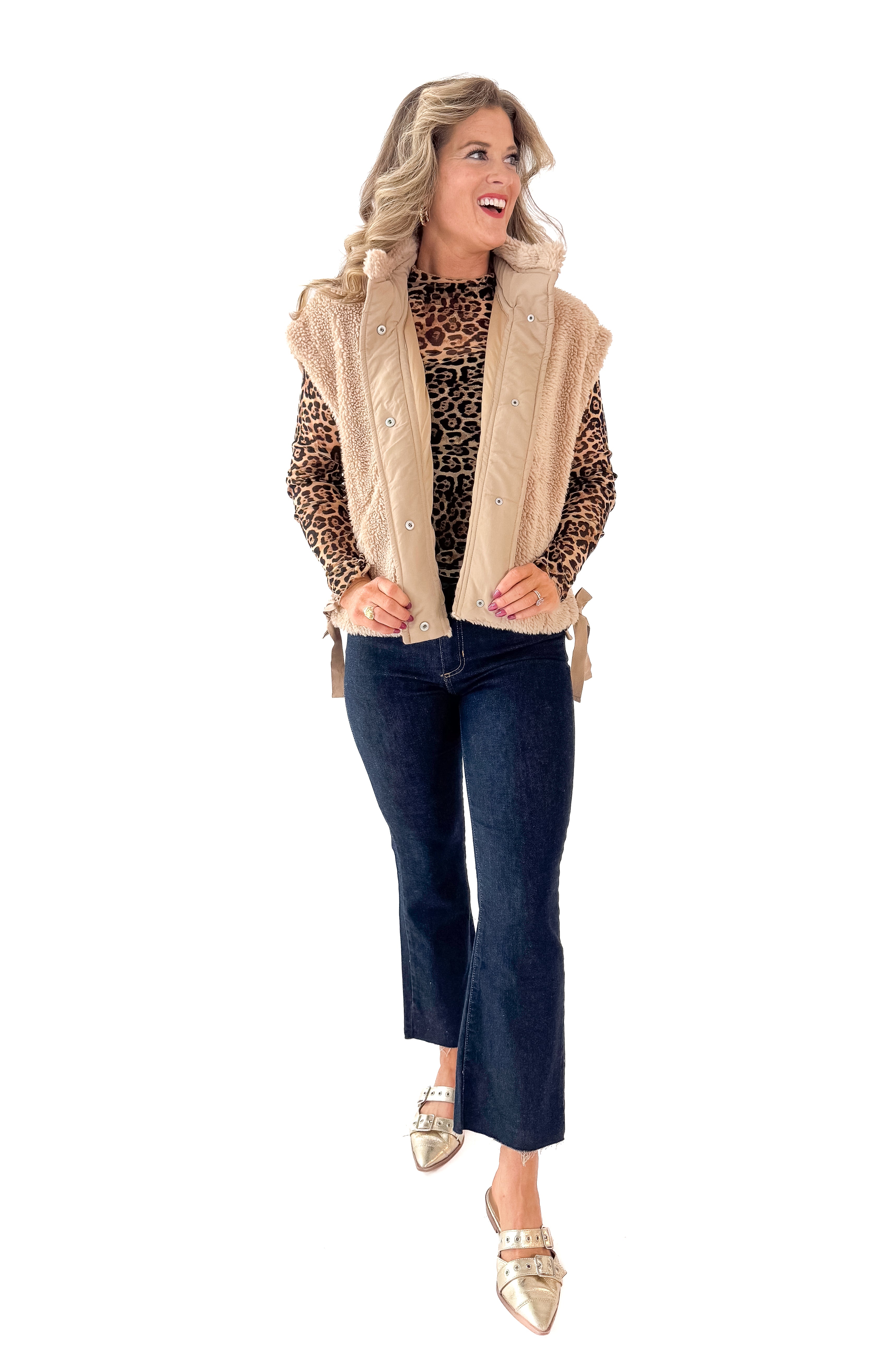 Front view of woman wearing Taupe Sherpa Button Up Vest with jeans against white studio background.