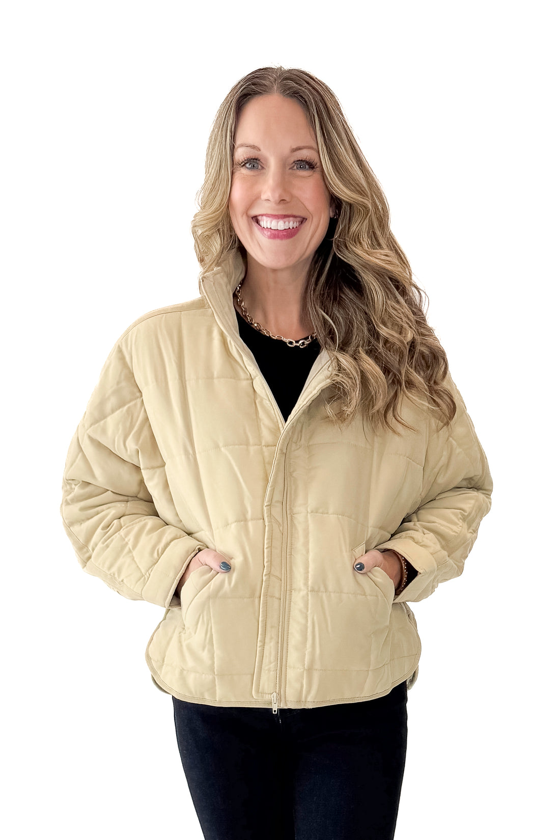 Front view of woman wearing Beige Quilted Puffer Jacket with jeans against white studio background.
