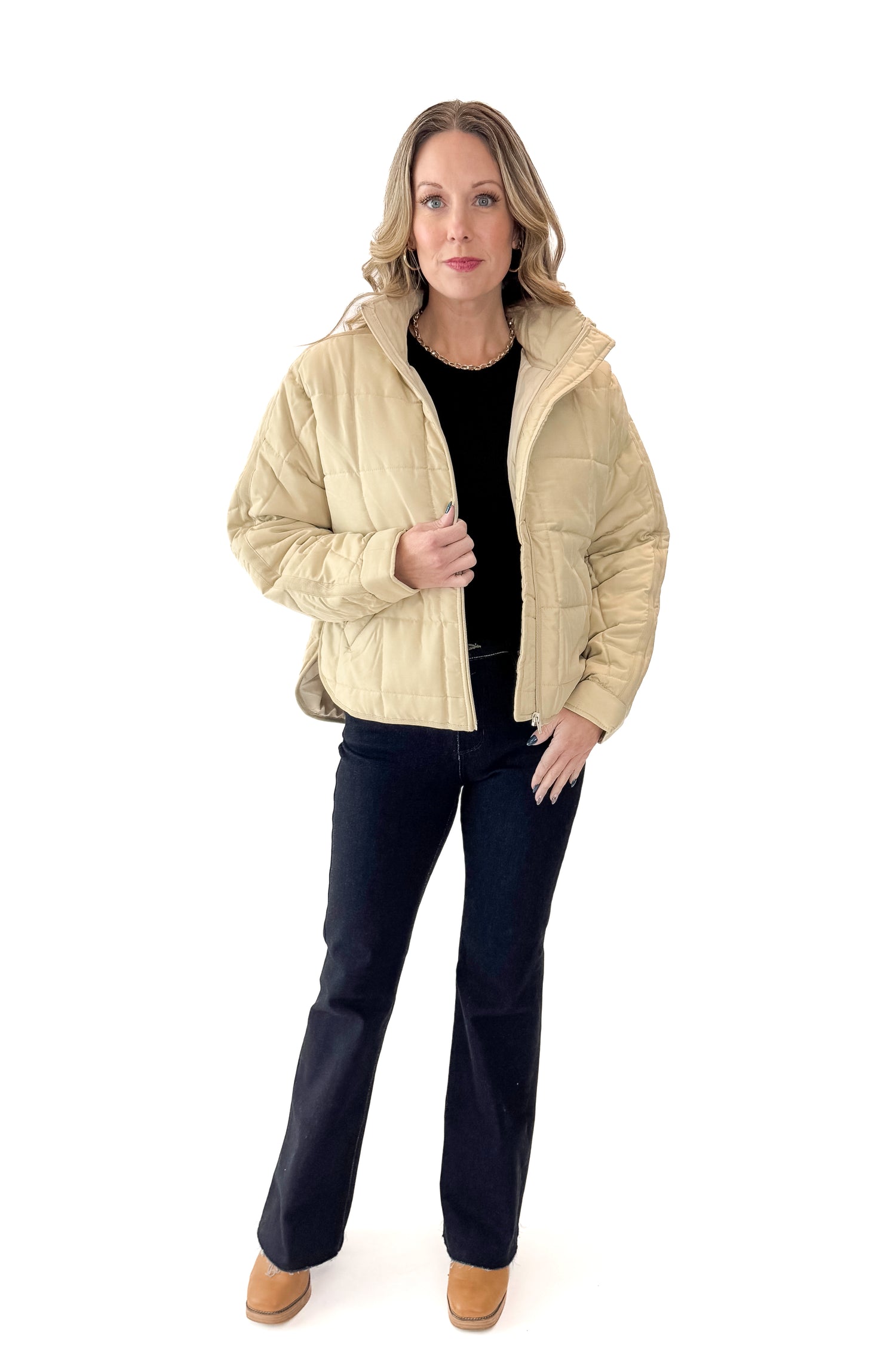 Front view of woman wearing Beige Quilted Puffer Jacket with jeans against white studio background.