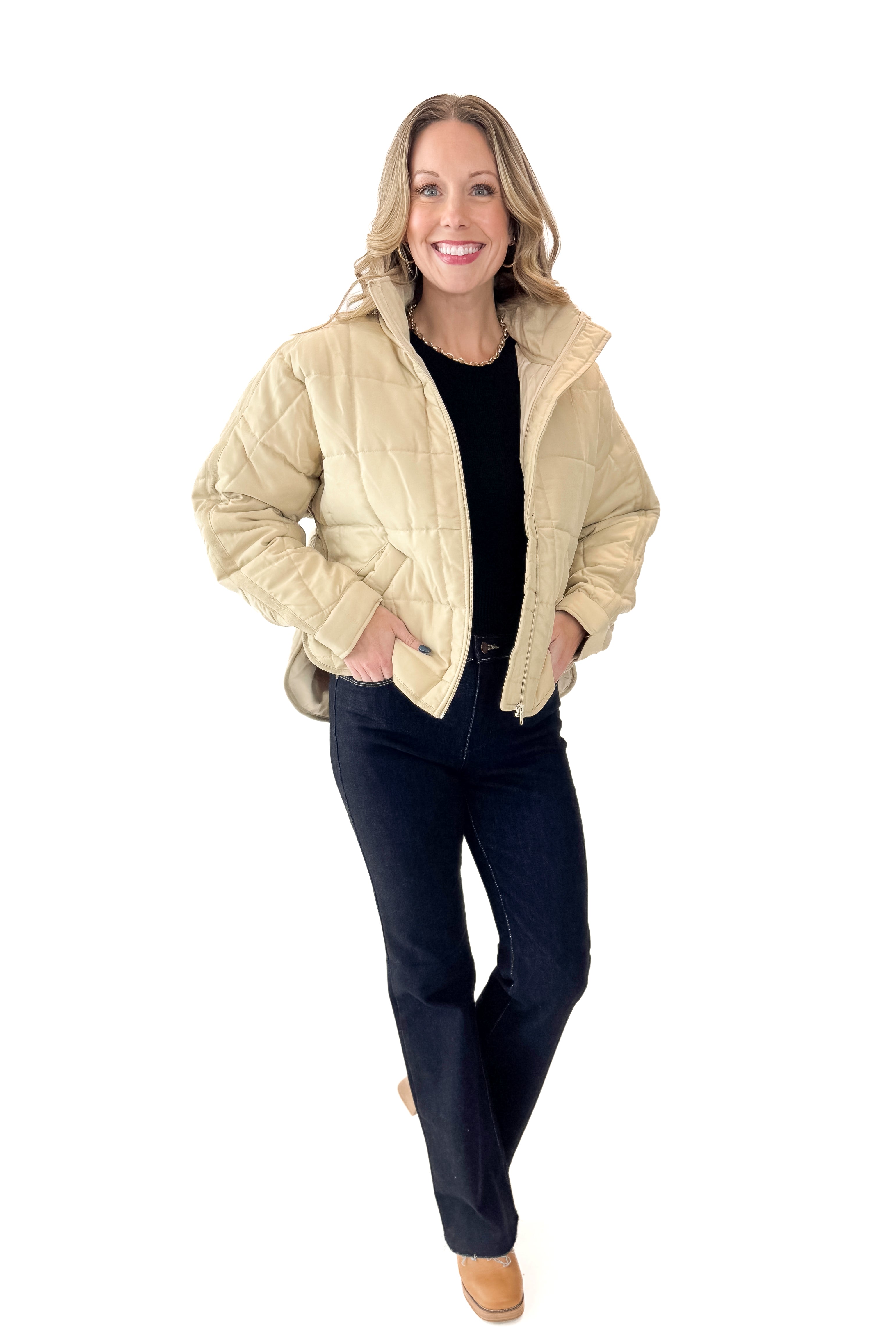 Front view of woman wearing Beige Quilted Puffer Jacket with jeans against white studio background.