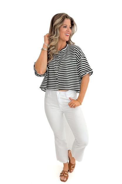 Front view of woman wearing Black &amp; White Striped Button Up Tee with jeans against white studio background.