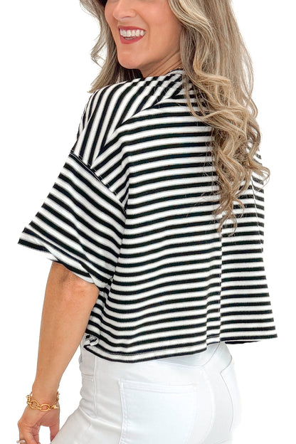 Side detail view of woman wearing Black &amp; White Striped Button Up Tee with jeans against white studio background.