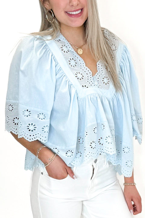 Front detail view of woman wearing Light Blue Eyelet Babydoll Top with jeans against white studio background.