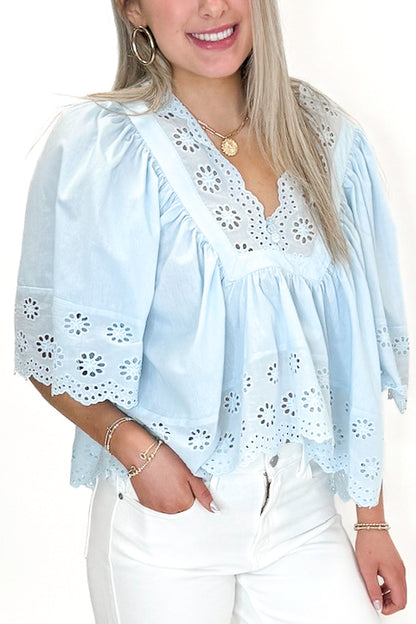 Front detail view of woman wearing Light Blue Eyelet Babydoll Top with jeans against white studio background.