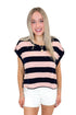 Front view of woman wearing Navy & Pink Striped Cut Out Back Tee with jean shorts against white studio background.