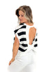 Back cut out view of woman wearing Black & White Striped Cut Out Back Tee with jeans against white studio background.