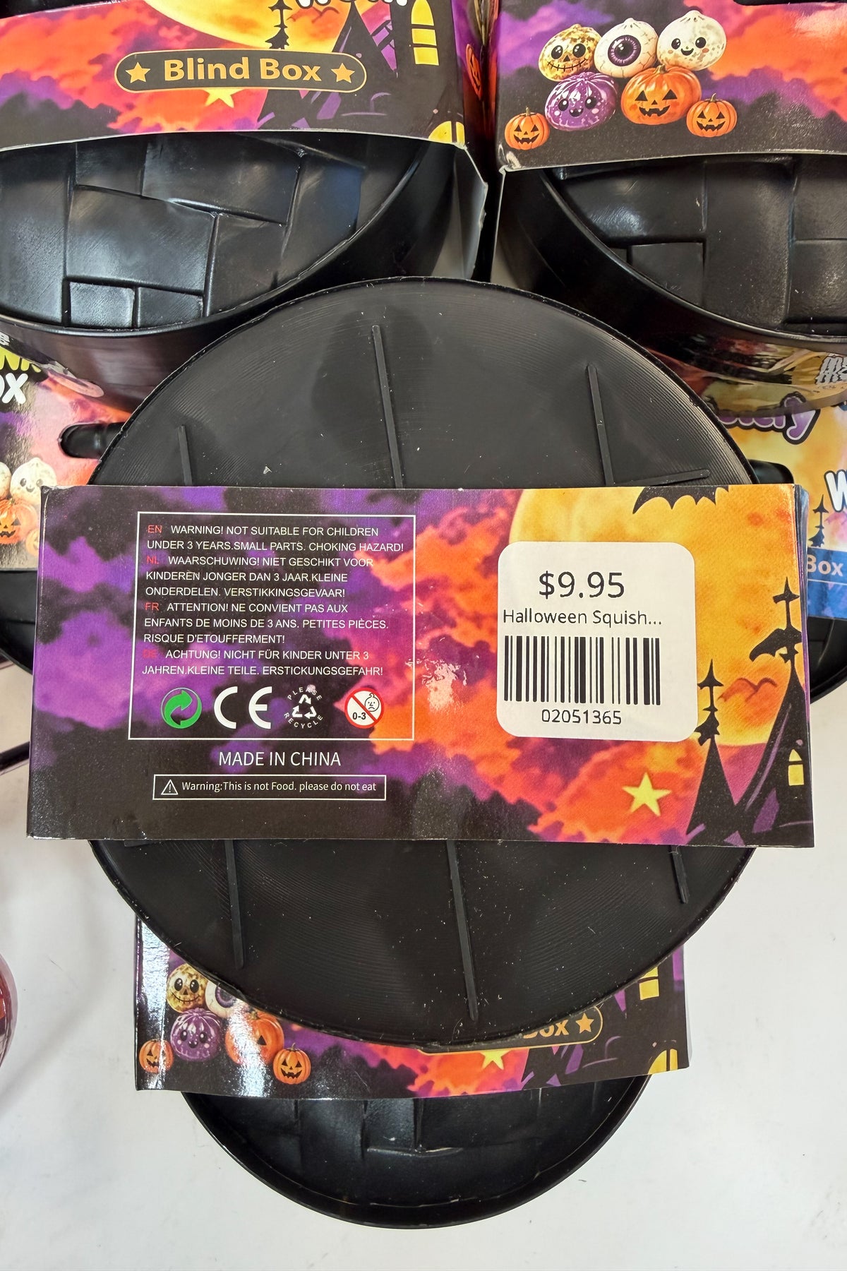 A black plastic Halloween squishy toy with its retail packaging, showing a price tag of $9.95.
