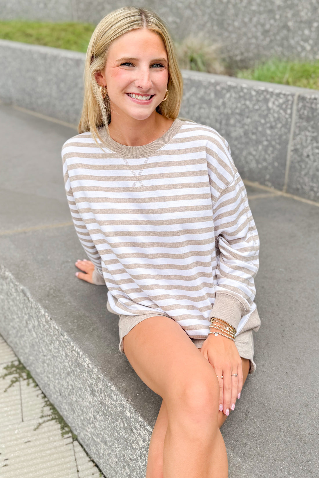 Front view of woman wearing Swagger Boutique’s Heather Ash The Everyday Striped Crew with Heather Ash The Everyday Short sitting outside at a park.