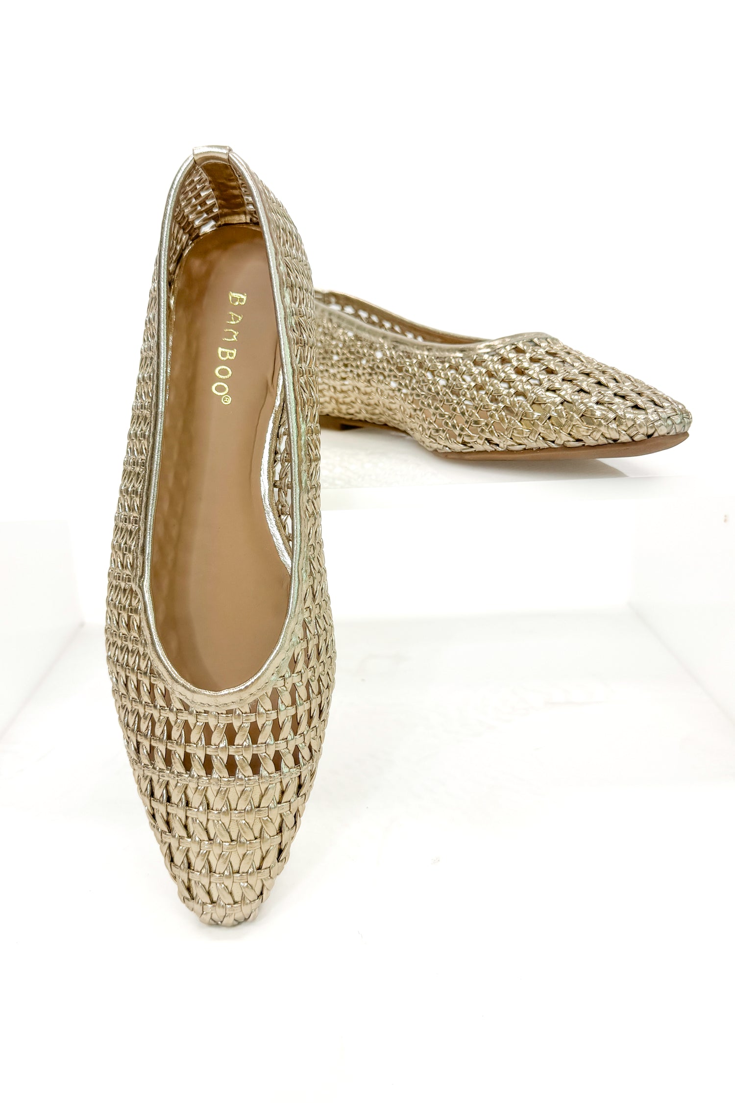 Swagger Boutique’s sweater Highway- Gold Woven Flats against white studio background.