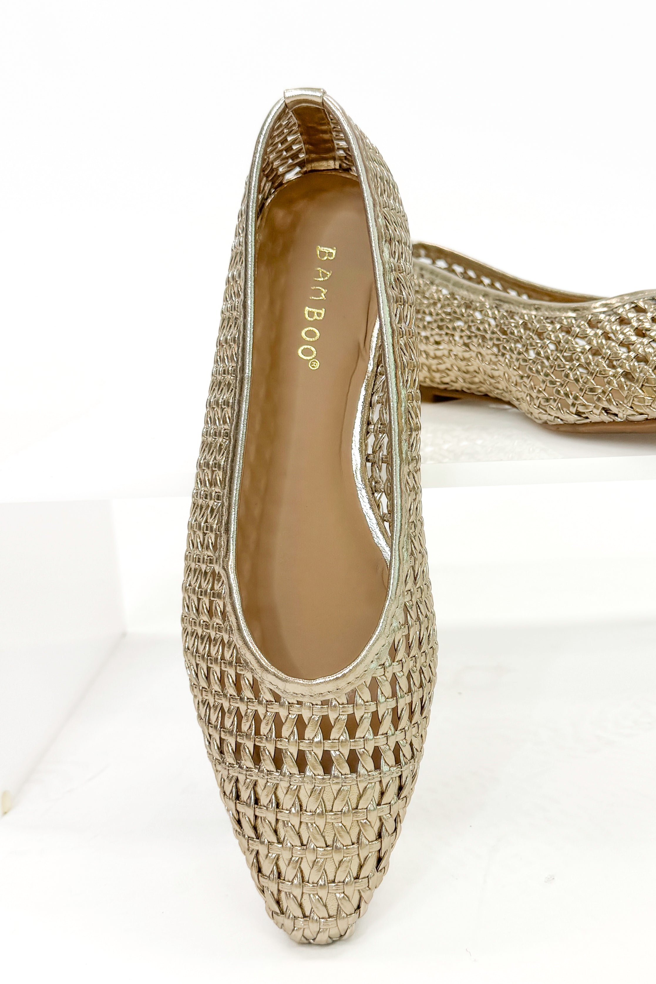 Swagger Boutique’s sweater Highway- Gold Woven Flats against white studio background.