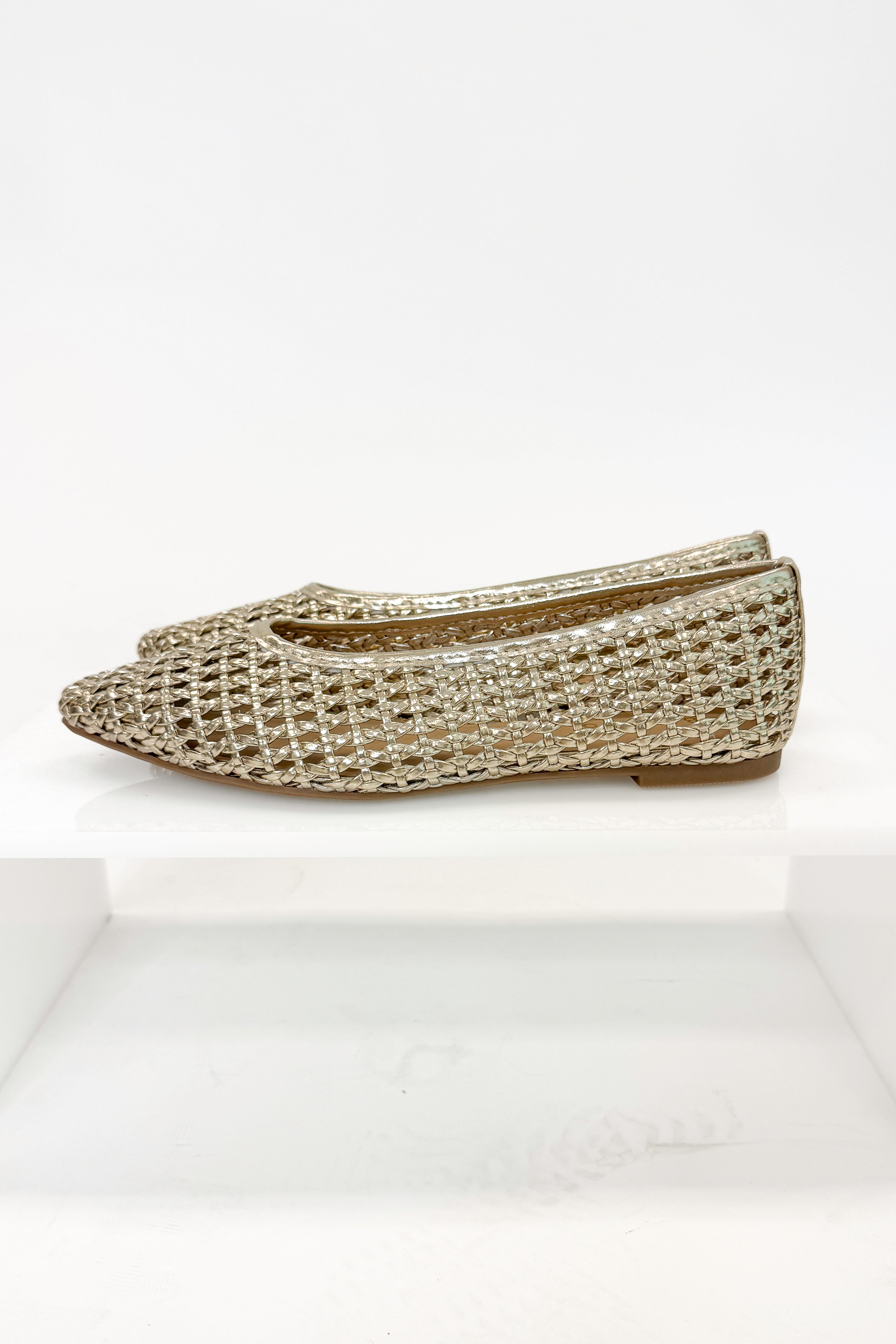 Swagger Boutique’s sweater Highway- Gold Woven Flats against white studio background.